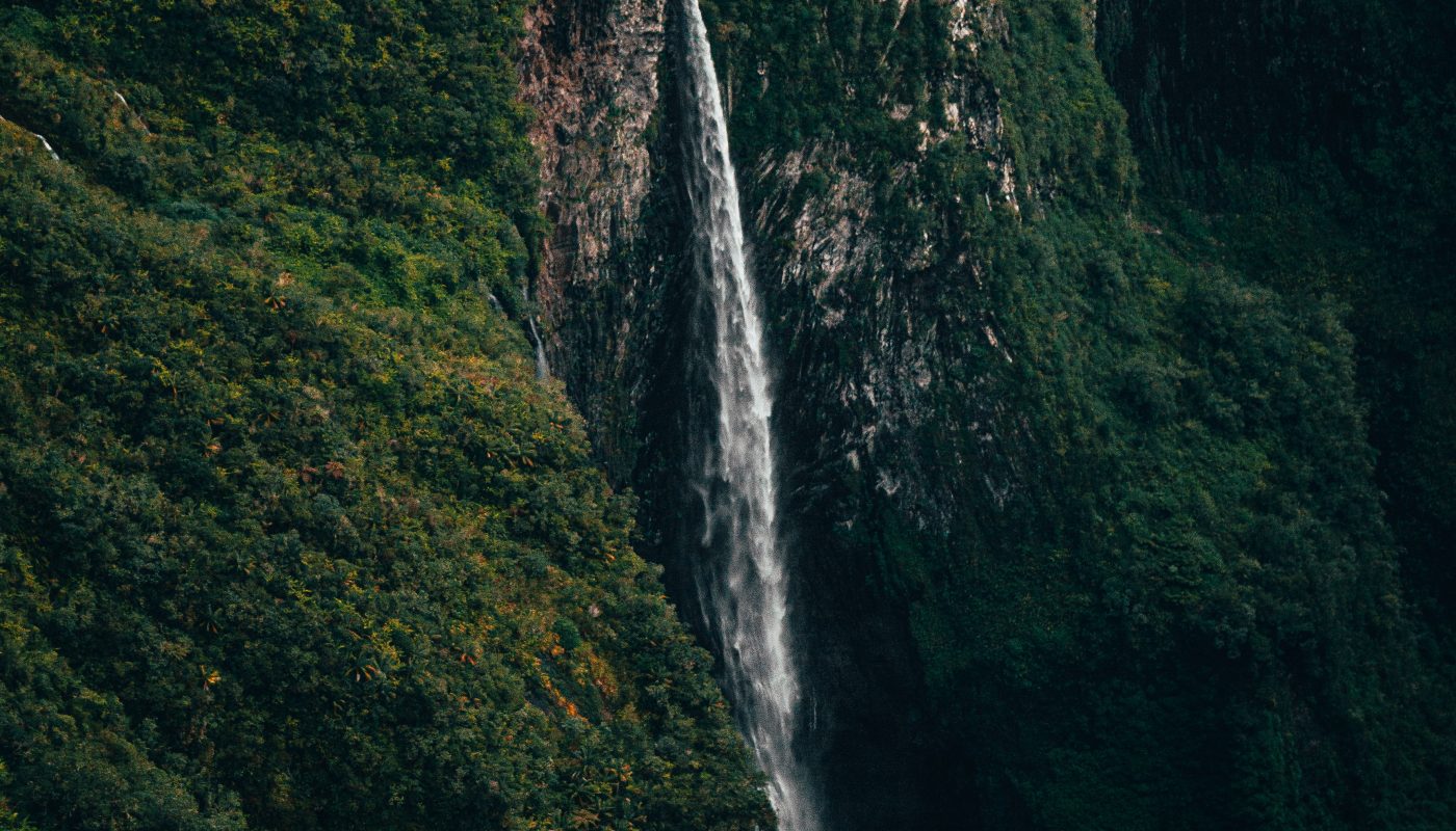 waterfalls in the middle of green mountain