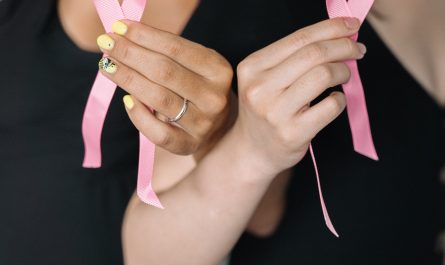 2 women holding pink ribbons