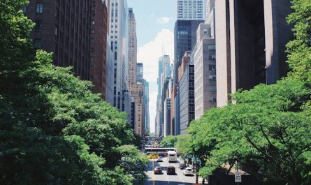 yellow car running on the street between the building during daytime